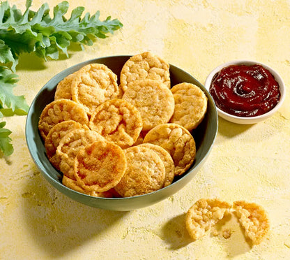 Bowl of Herbalife Barbeque flavour protein chips with a side of barbeque sauce on a yellow background