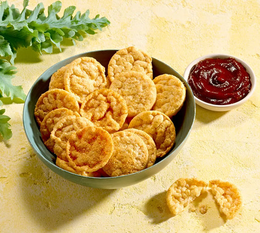 Bowl of Herbalife Barbeque flavour protein chips with a side of barbeque sauce on a yellow background